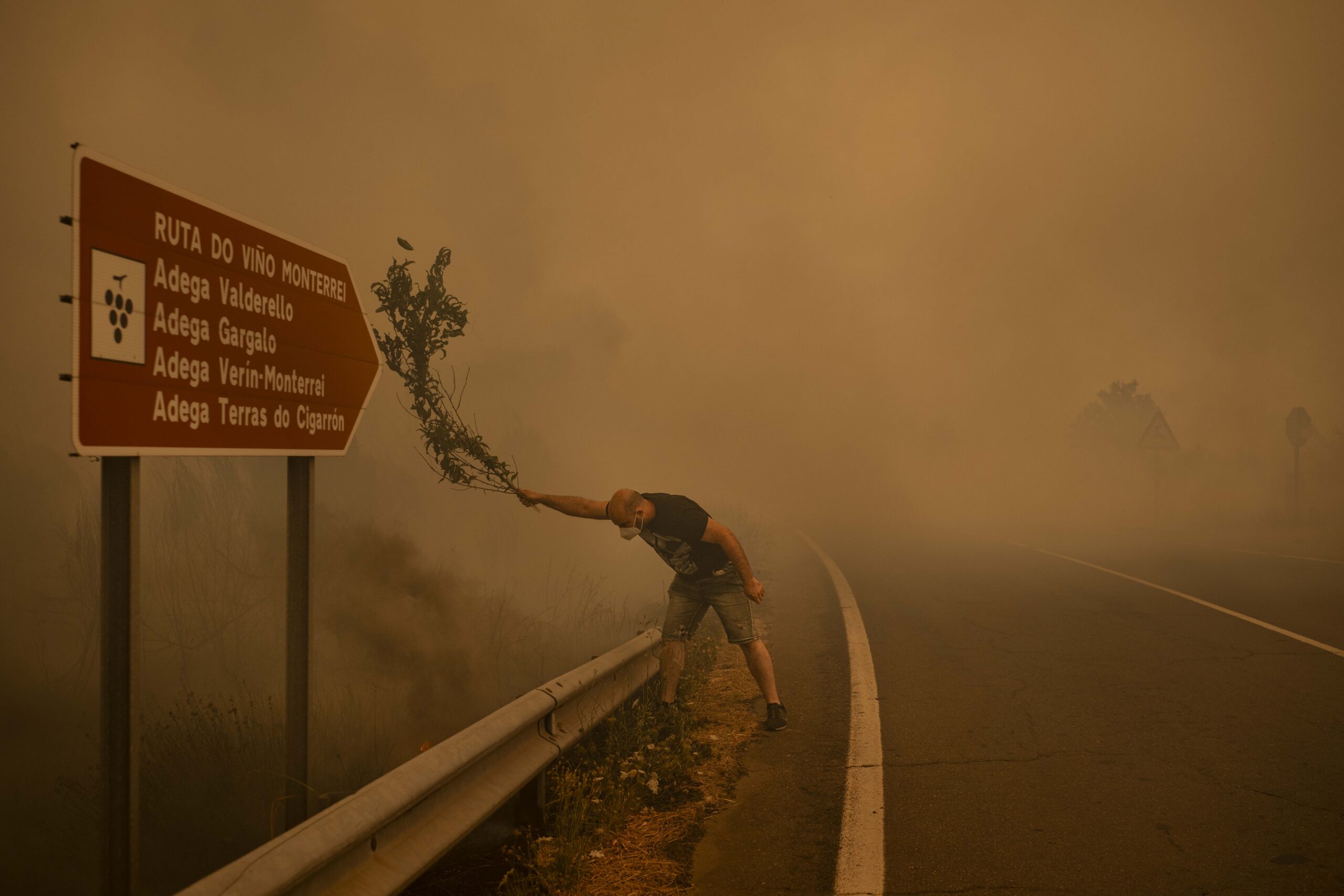 Un home loita contra o incendio cunha póla en Cualedro, Galicia, o 15 de agosto de 2025. Os incendios combátense con todos os medios dispoñibles: mangueiras, hidroavións, pero tamén con pólas.